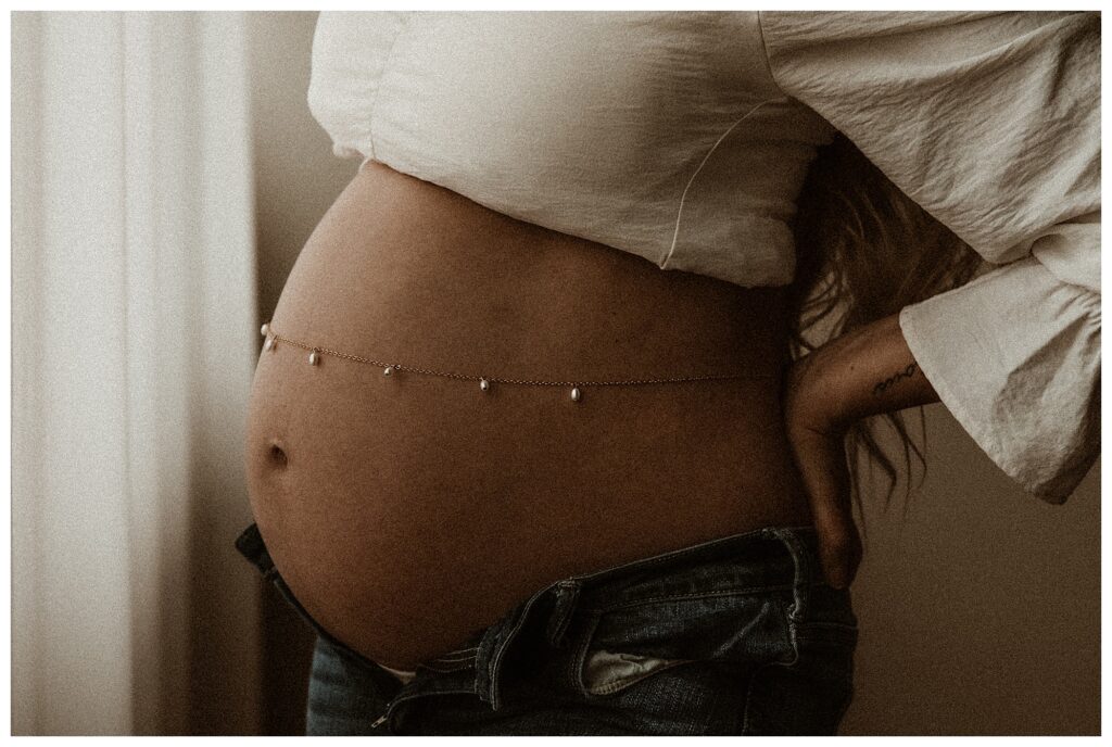close up of belly chain on pregnant mothers bump jeans and white shirt classic artistic maternity session O'fallon missouri