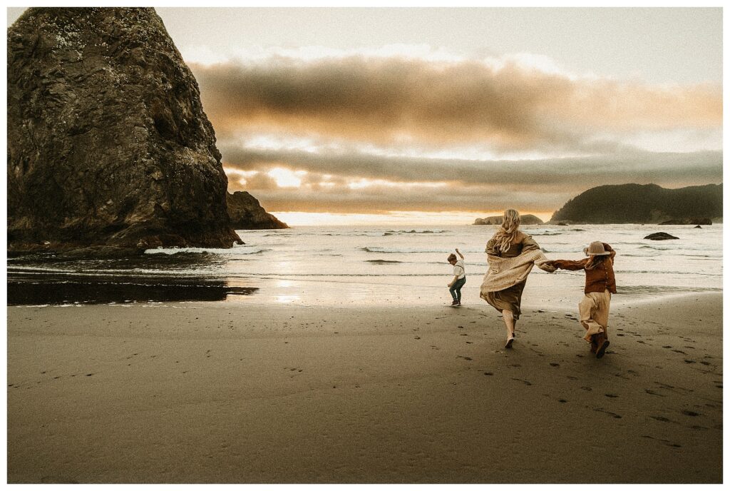 mother and daughter running towards the ocean on moody outdoor sunset session in Oregon with Stormy Solis workshop Rebecca Stephenson fine art family photographer St Louis Missouri
