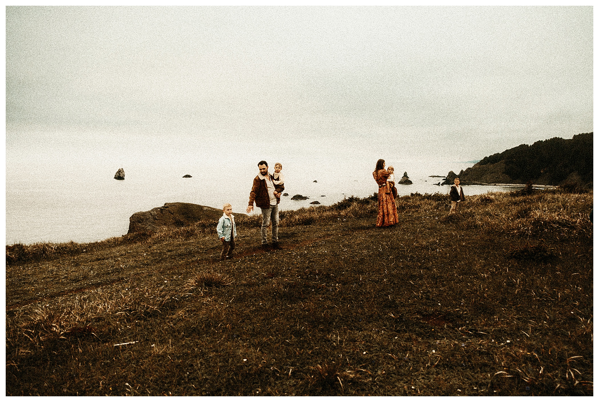 moody portrait of family taking a stroll at the beach and cliffs of Oregon fine art portrait