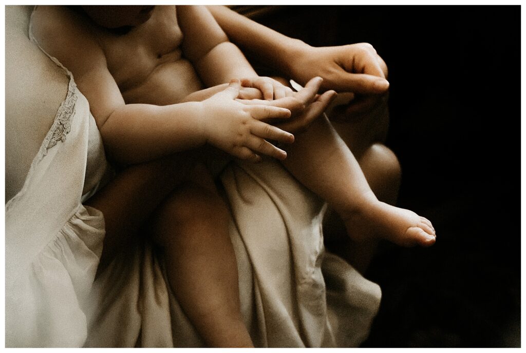 hands closeup baby and mother in silk nightgown indoor fine art family photography