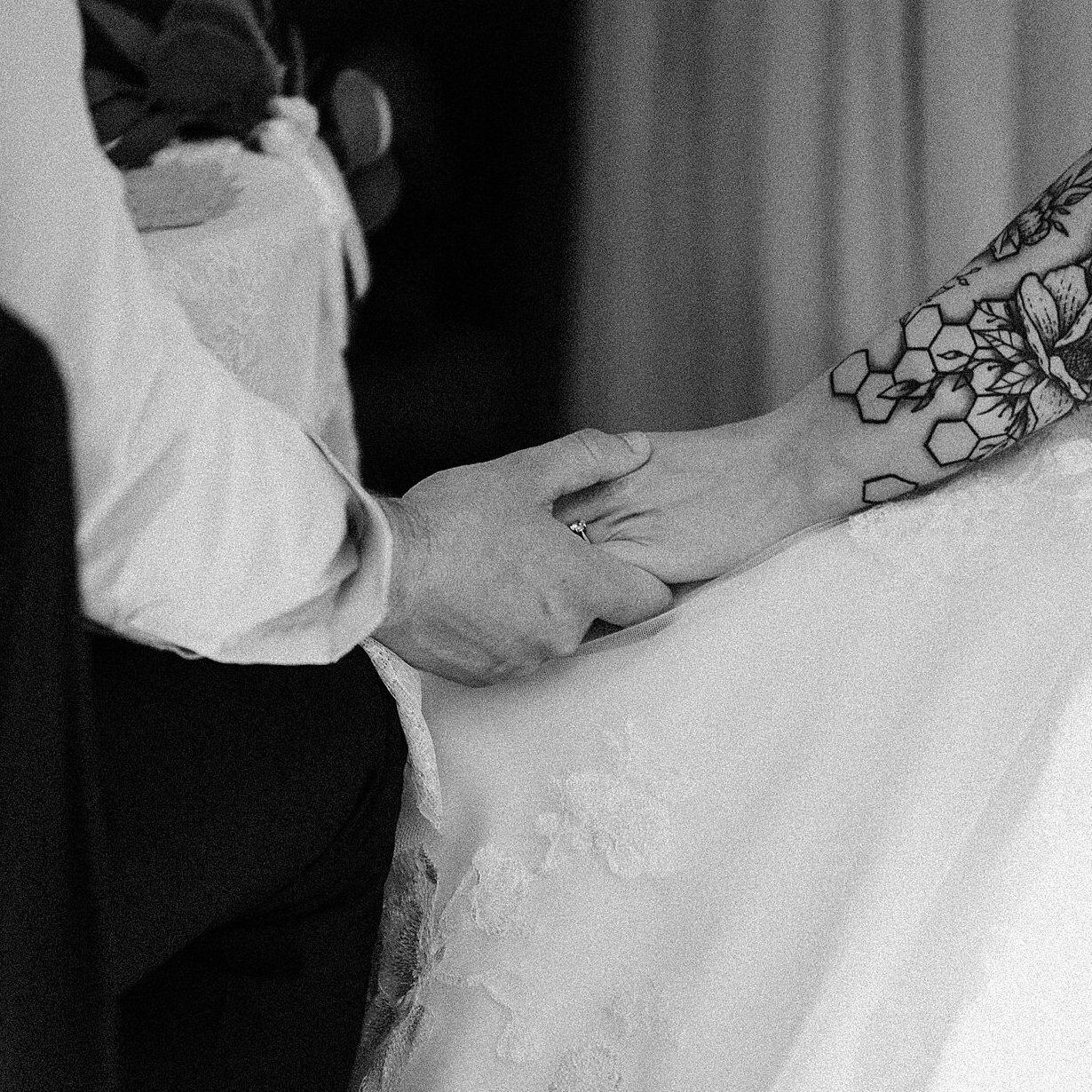 close up shot of groom holding brides hand