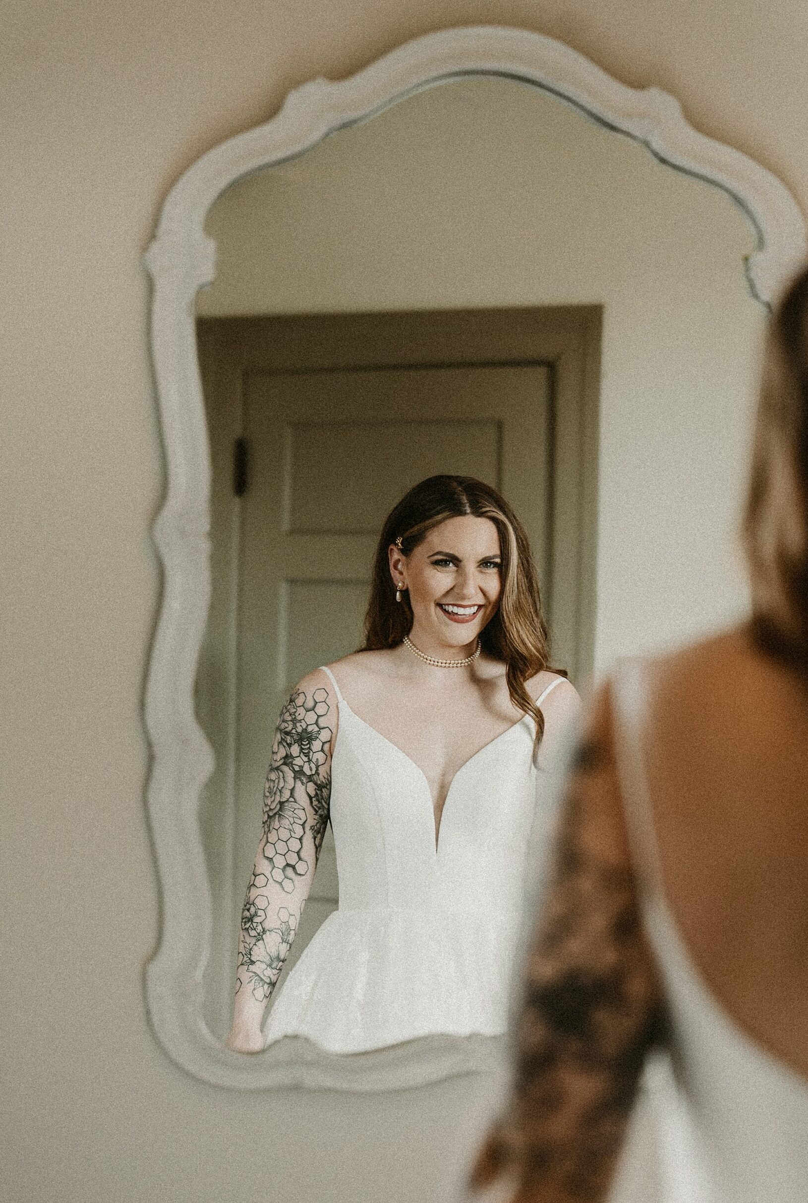 Bride looking in mirror at das Bevo wedding venue