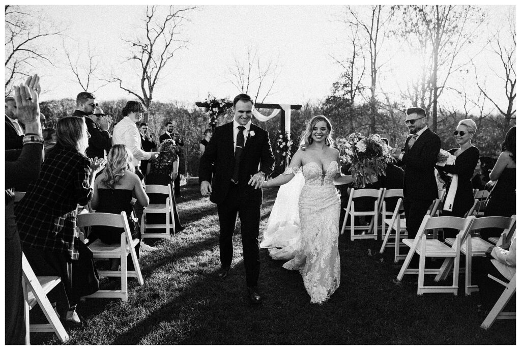 bride and groom walking down the aisle black and white