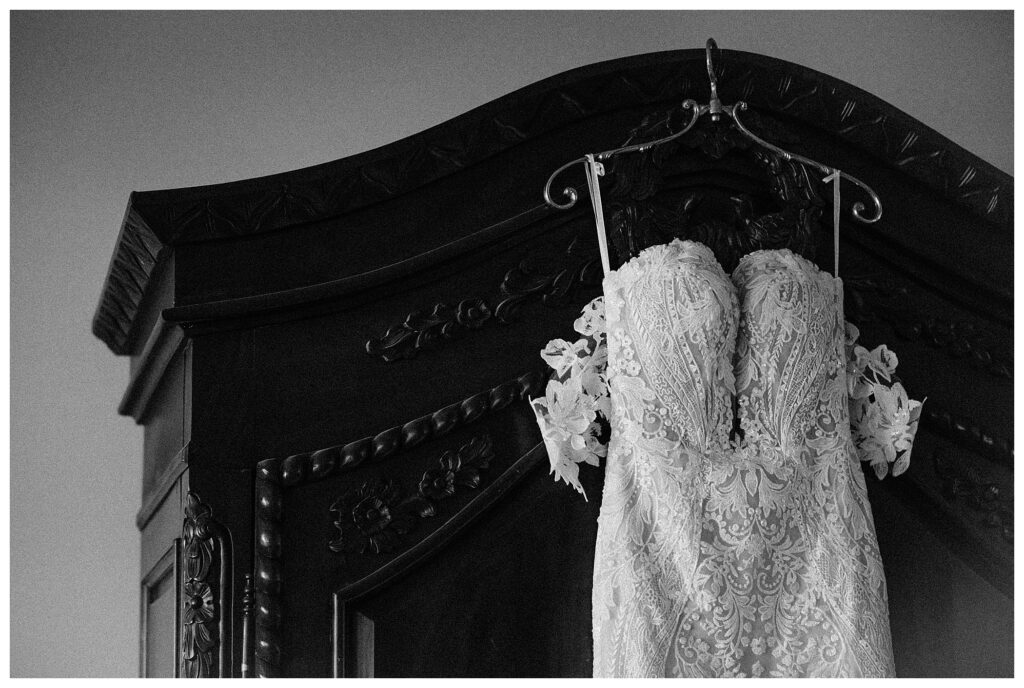 black and white detail shot of antique wedding gown hanging up